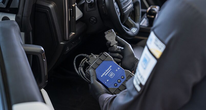 GMC Certified Service Technician Using a Vehicle Diagnostics Tool on a Hummer EV