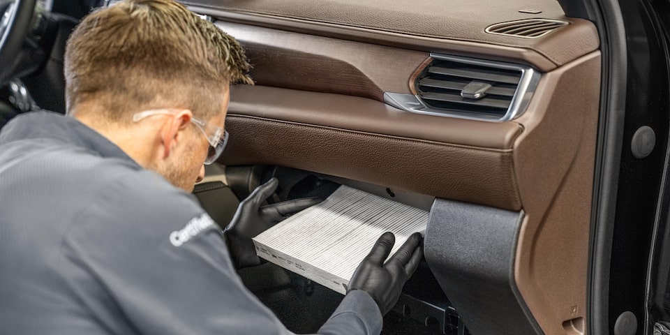 GMC Certified Service Technician Installing a Cabin Filter in a Vehicle
