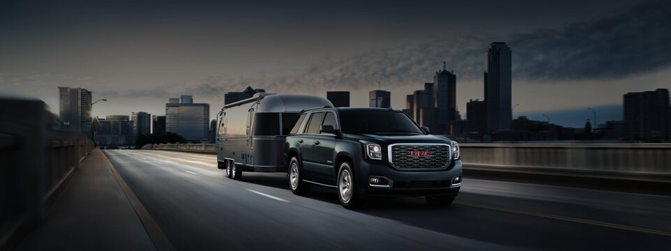 GMC Yukon Denali Full-size SUV Hauling Trailer in a City