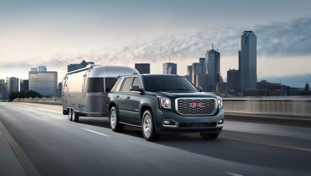 GMC Yukon Denali Full-size SUV Hauling Trailer in a City