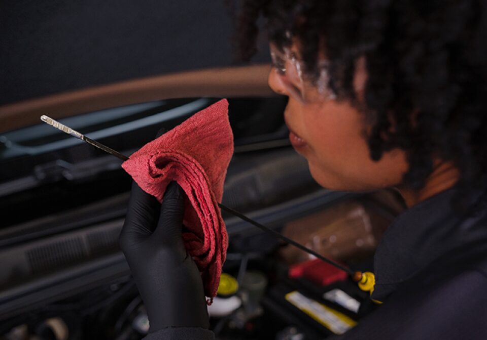 Service Technician Checks Oil In Vehicle
