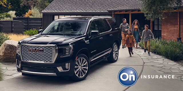 GMC Yukon Large SUV sits in the driveway while a family of four exits the house and is walking toward the vehicle. OnStar Insurance logo is in the bottom right corner of the image