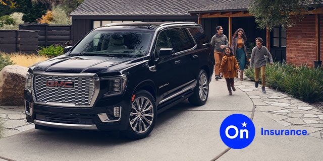 GMC Yukon Large SUV sits in the driveway while a family of four exits the house and is walking toward the vehicle. OnStar Insurance logo is in the bottom right corner of the image