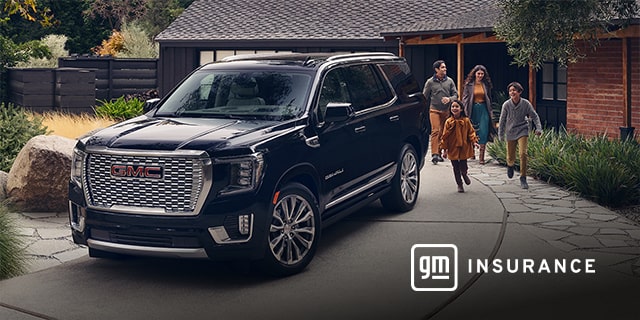 GMC Yukon Large SUV sits in the driveway while a family of four exits the house and is walking toward the vehicle. General Motors Insurance logo is in the bottom right corner of the image