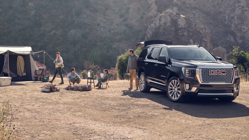 Family Setting Up Camping Tents Next to Their GMC Sierra Truck