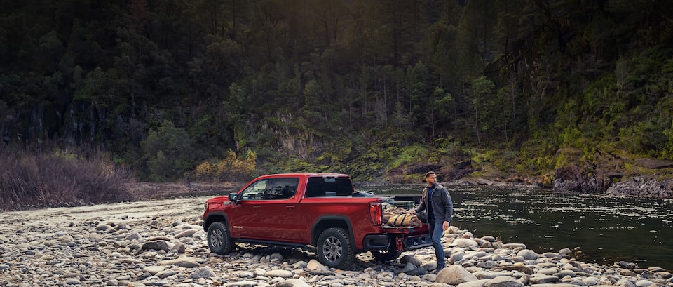 Man gathering camping gear out of his GMC truck