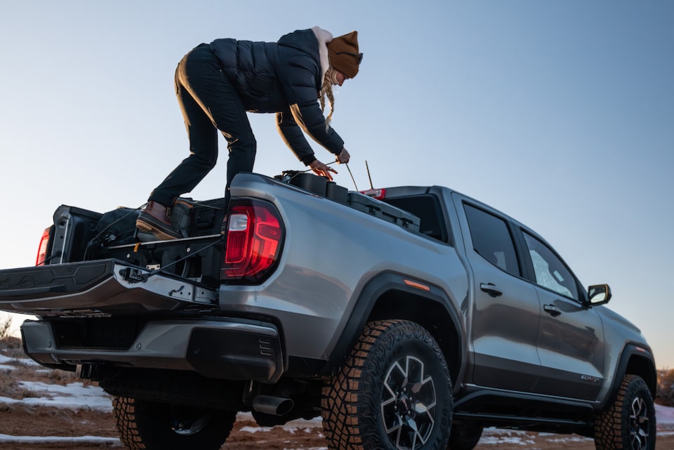 Women in bed of GMC Sierra