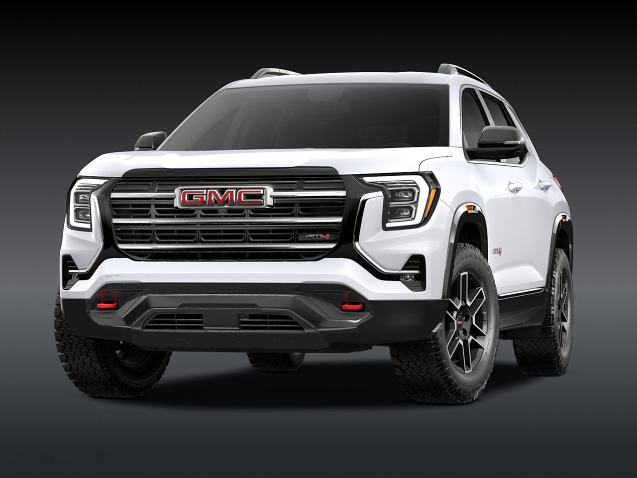A Front Exterior View of a Pristine White GMC AT4 SUV with a Prominent Grille Headlights and Rugged Tires