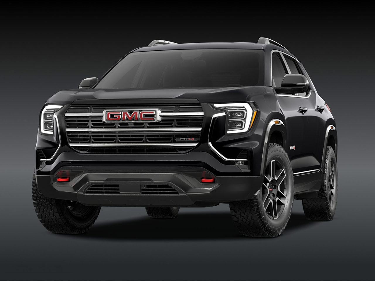 A Front Exterior View of a Sleek Black GMC AT4 SUV with a Prominent Grille Headlights and Rugged Tires