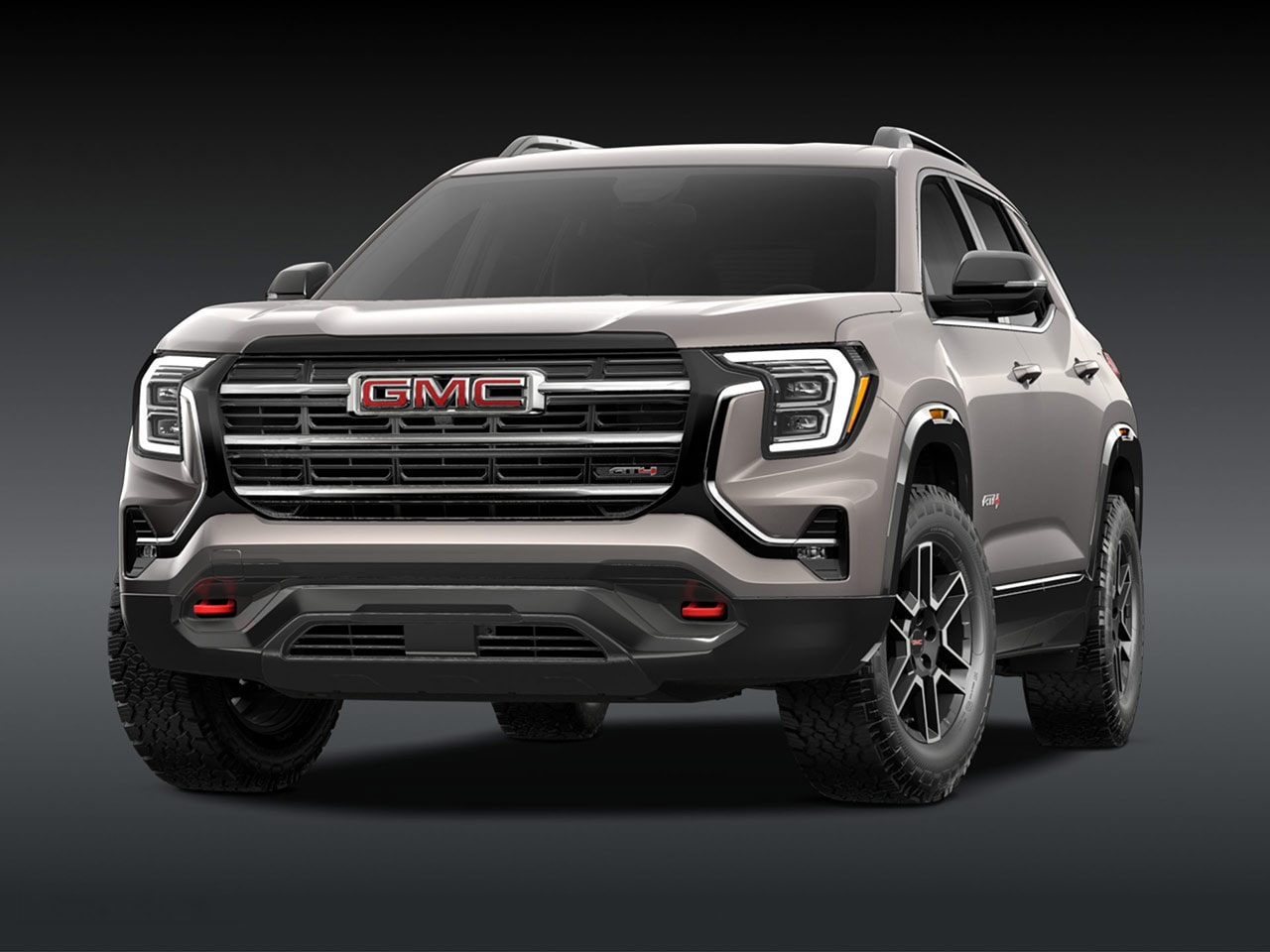 A Front Exterior View of a Light Brown GMC AT4 SUV with a Prominent Grille Headlights and Rugged Tires