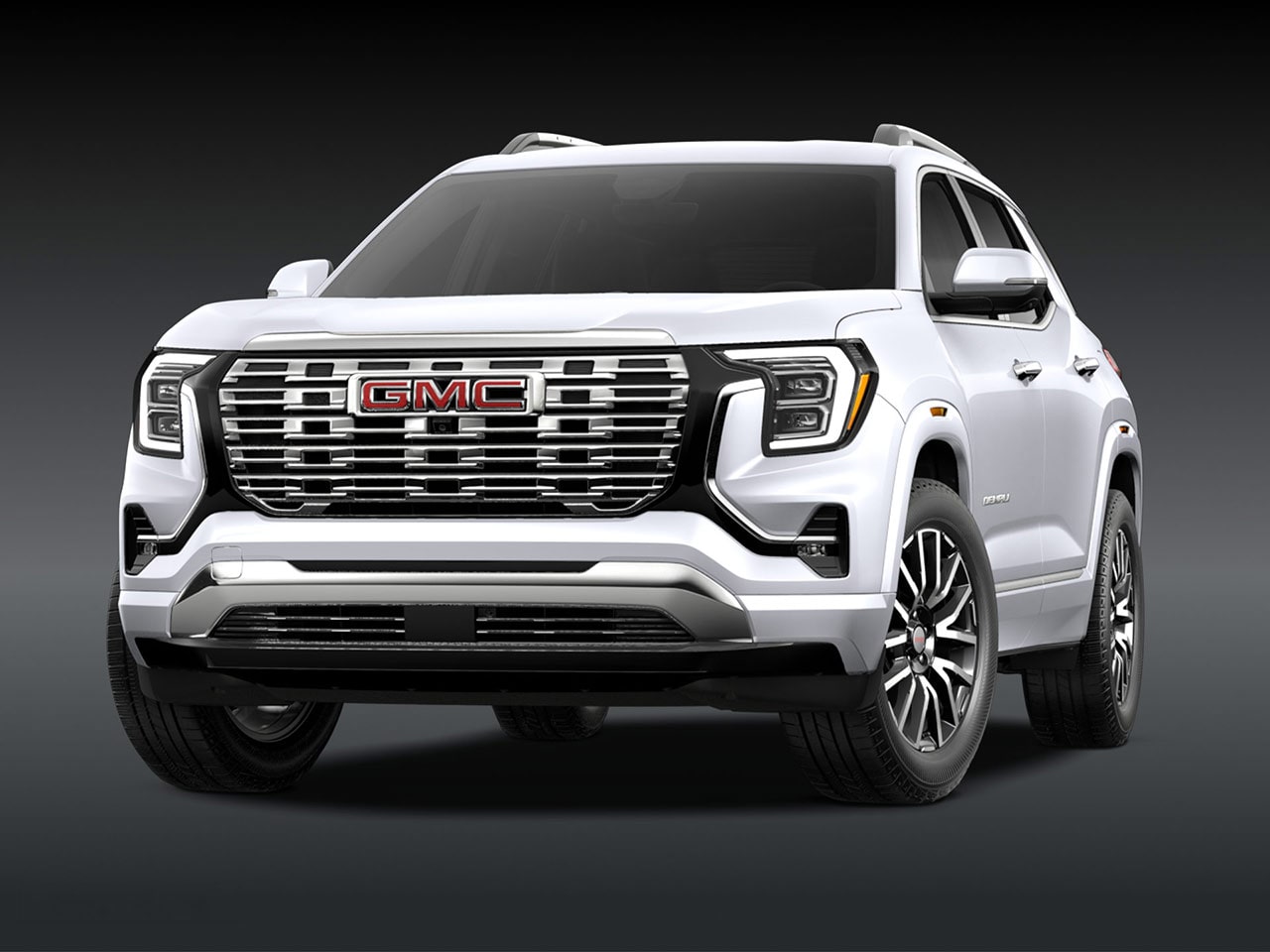 A Front Three-Quarter View of the White 2026 GMC Denali SUV on a Dark Background