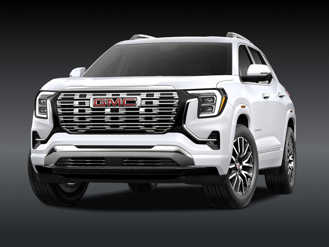 A Front Three-Quarter View of the White 2026 GMC Denali SUV on a Dark Background