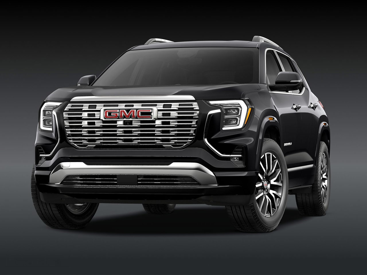 A Front Three-Quarter View of the Black 2026 GMC Denali SUV on a Dark Background