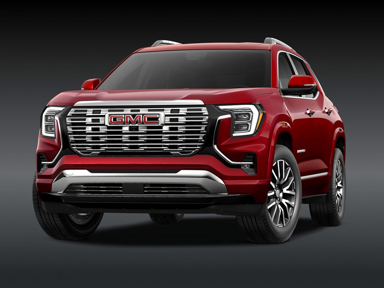 A Front Three-Quarter View of the Red 2026 GMC Denali SUV on a Dark Background
