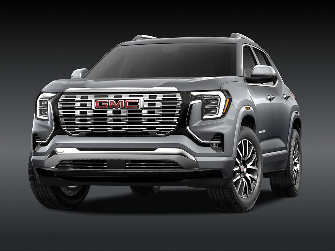 A Front Three-Quarter View of the Silver 2026 GMC Denali SUV on a Dark Background
