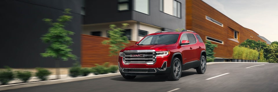 GMC Vehicle Driving Down a City Street