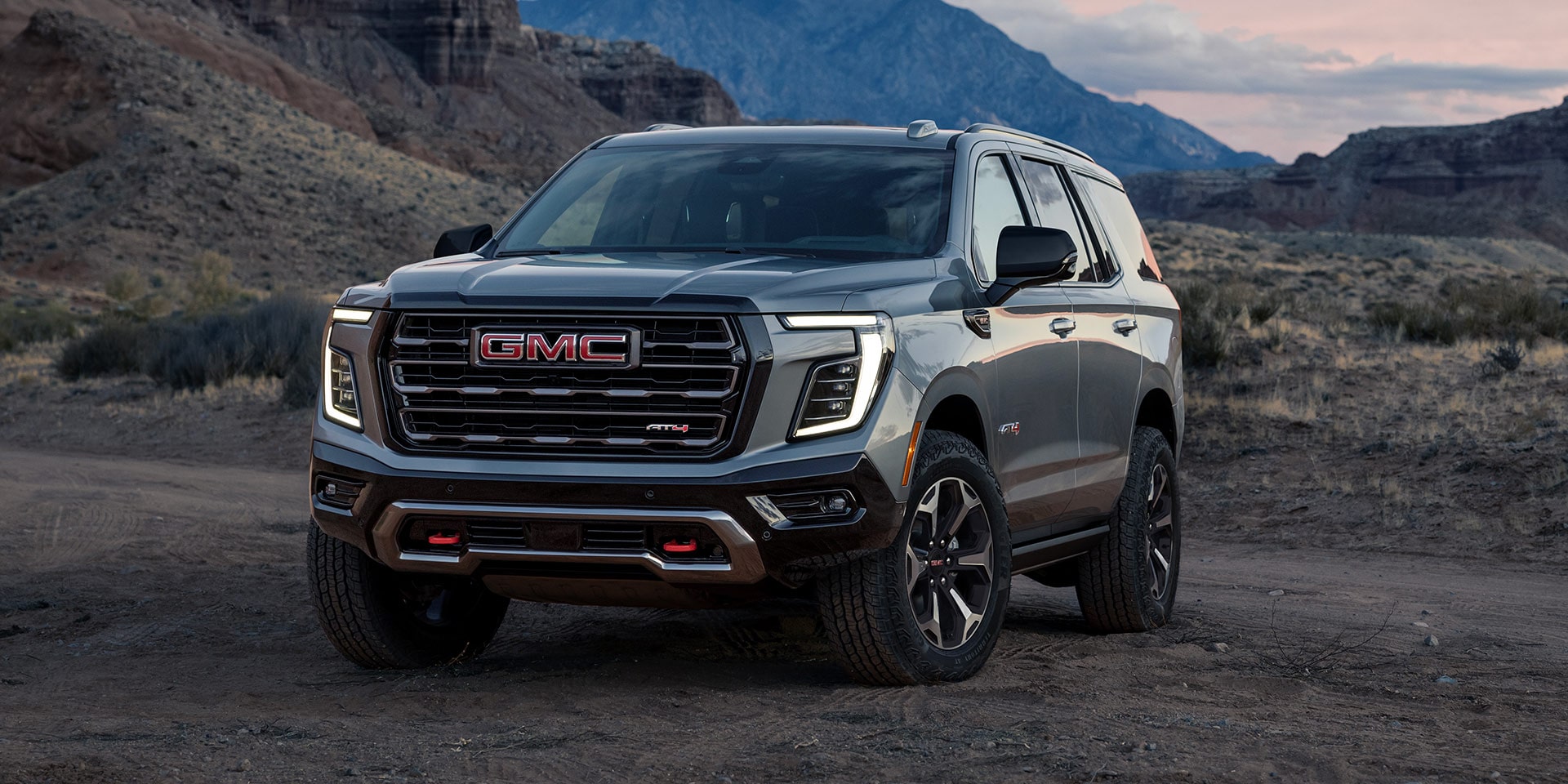 Front Three-Quarters View of the GMC Yukon AT4X Full-Size Off-Road SUV Parked on a Scenic Field