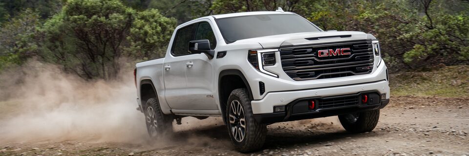 Side view of 2023 GMC Sierra Limited AT4 parked on a grassy path
