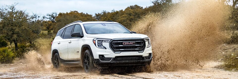 GMC Terrain AT4 Three-Quarters Front View Driving on Dirt Road 
