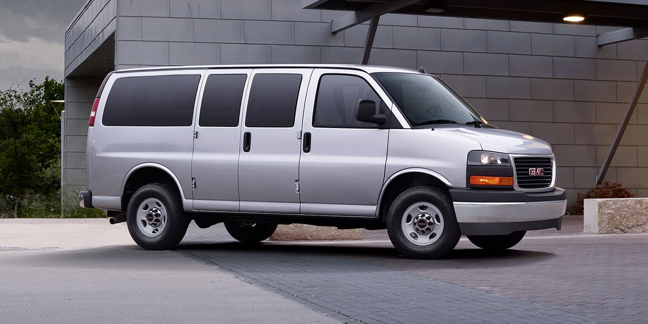 Front Three-Quarters View of the GMC Commercial Savana Passenger Van in a Parking Lot