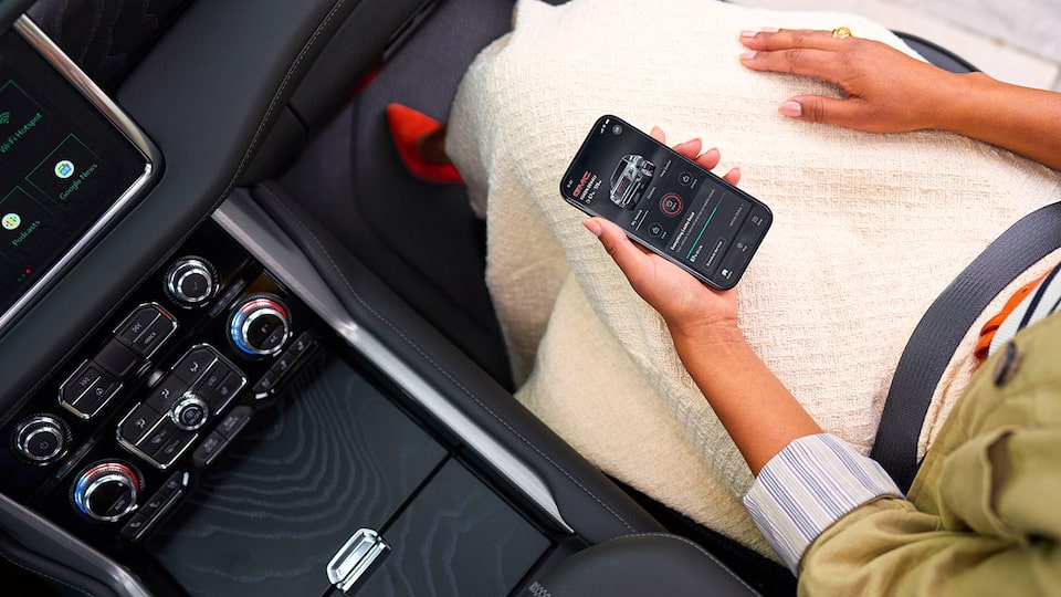 Over Head View of a Woman Sitting in the Passenger Seat of a GMC Vehicle Using her Smartphone