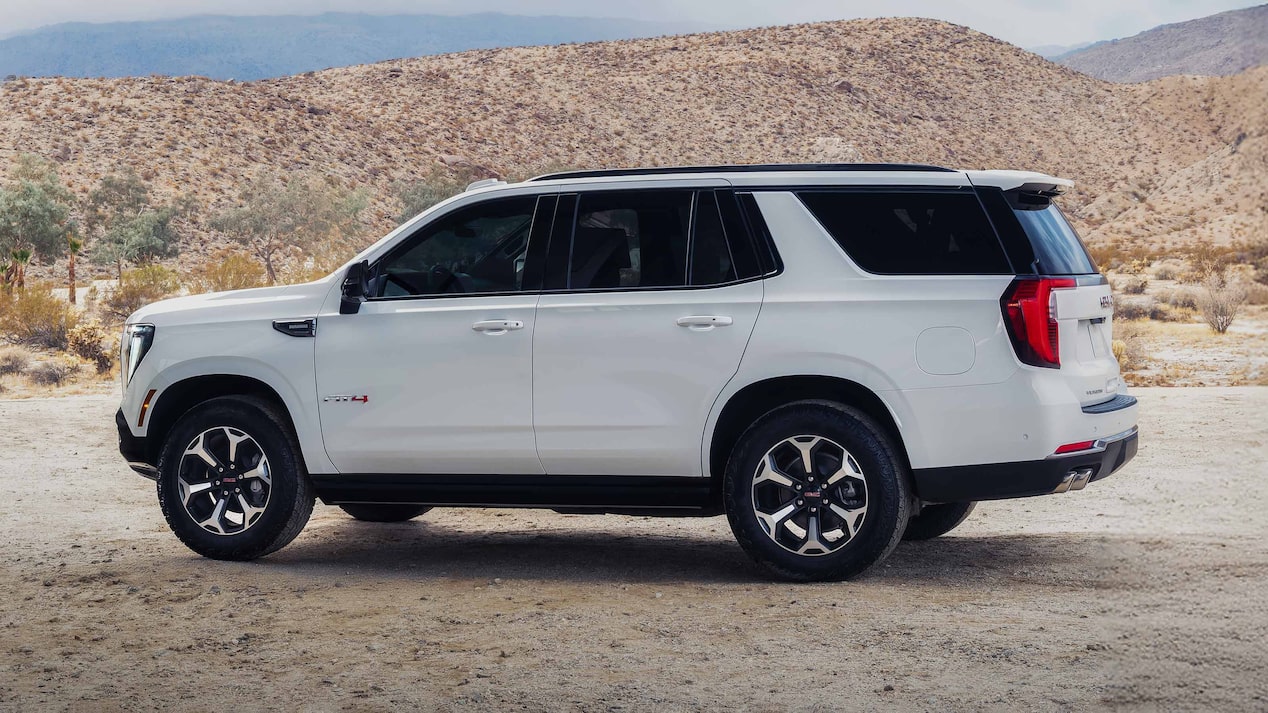 A White GMC Yukon AT4X Parked on a Dirt Road with Rocky Hills in the Background