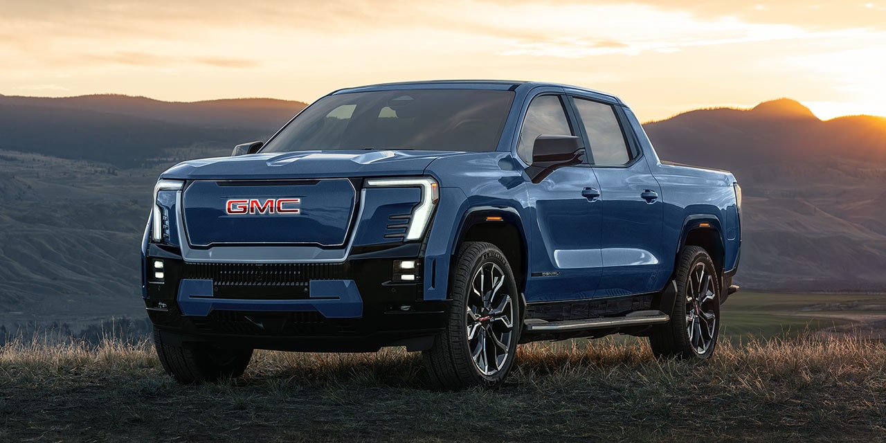 Front Three-Quarter View of the GMC Sierra EV Parked on a mountain at sunset