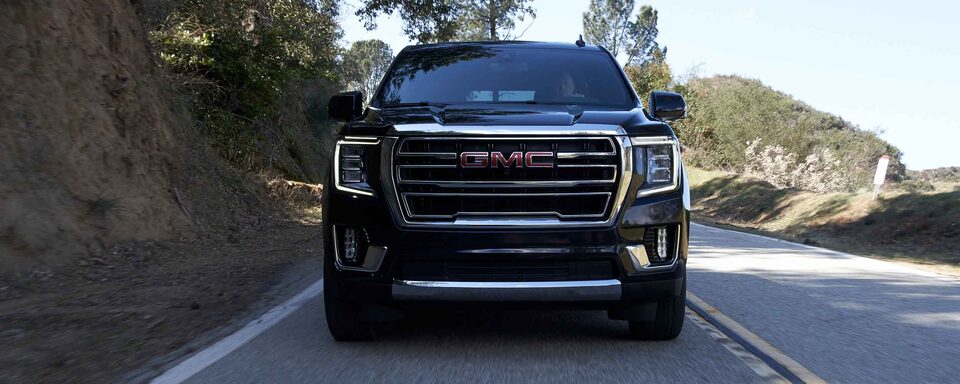2022 GMC Yukon SLT Full-Size SUV Driving on Road - Front Grille View
