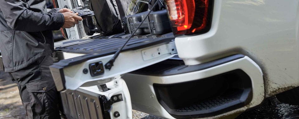 Man Loading Cargo Into Truck Bed of 2022 GMC Sierra HD AT4 Off-Road Truck