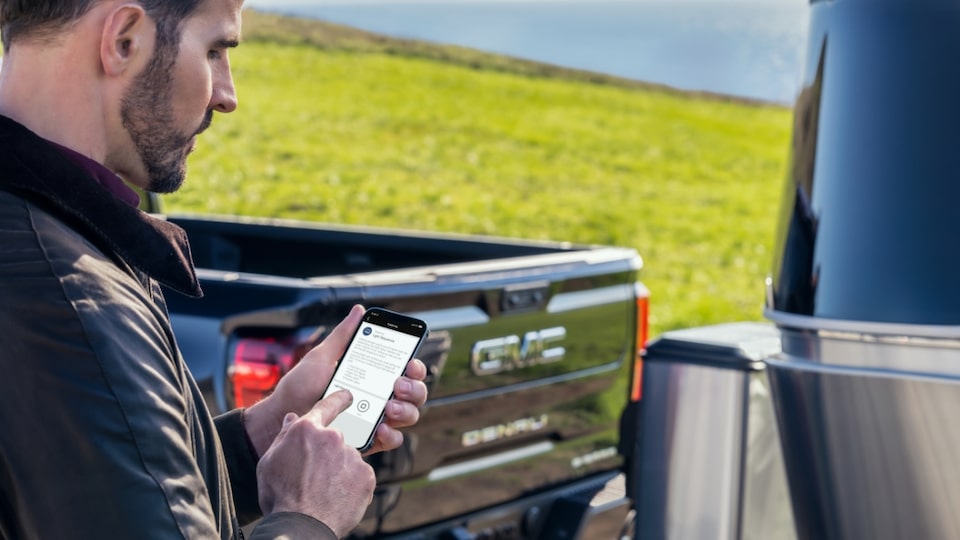 A Man use the GMC Mobile App for his new GMC Sierra Denali as he Prepares to Hit the Road