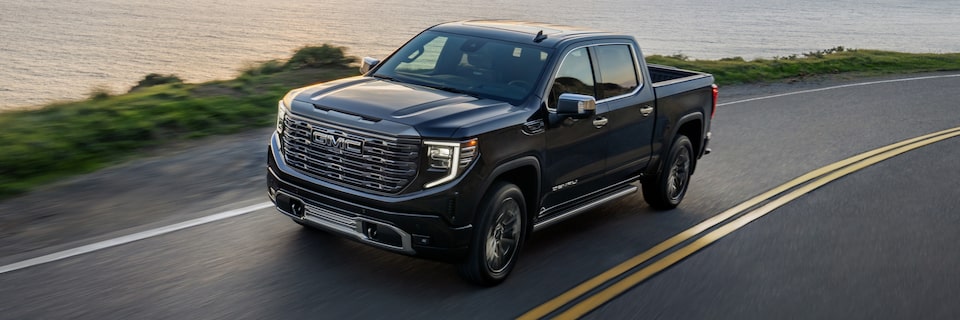 The Pacific Metallic Blue GMC Sierra Denali Cruising Along the Ocean