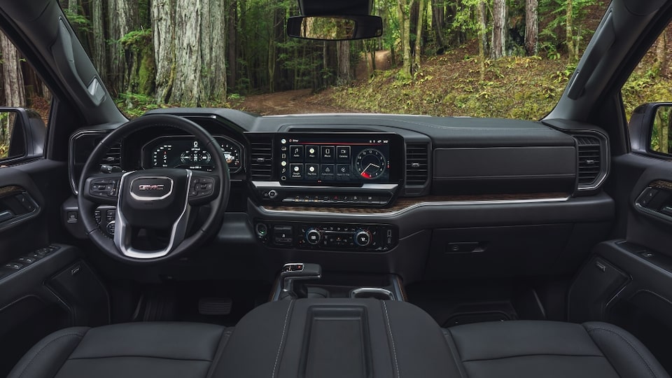 Steering Wheel, Heads-Up Display, and Infotainment System on the GMC Sierra SLE/SLT Parked Off-Road in Forest