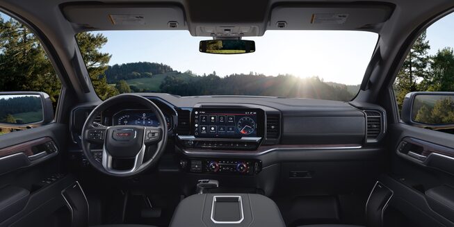 Steering Wheel, Heads-Up Display, and Infotainment System on the GMC Sierra SLE/SLT Parked Off-Road With Hills and Sunset