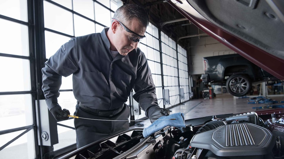 A GMC Mechanic Checking the Oil & Engine of the GMC Sierra HD Chassis Cab