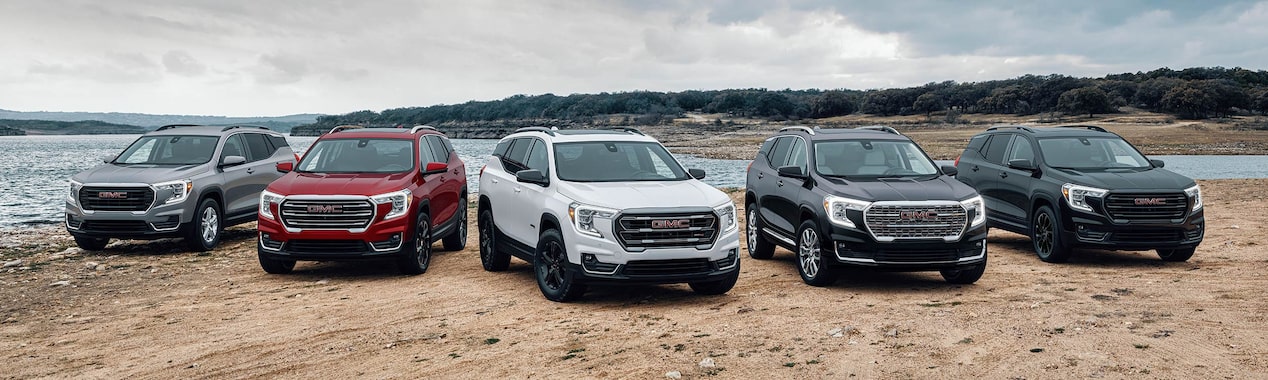 Five GMC Terrain models lined up in front of a body of water