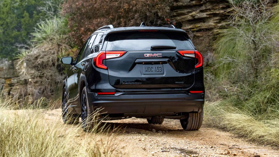 Marine Metallic GMC Terrain SLT Driving Off-Road With Dirt, Trees, and Hills