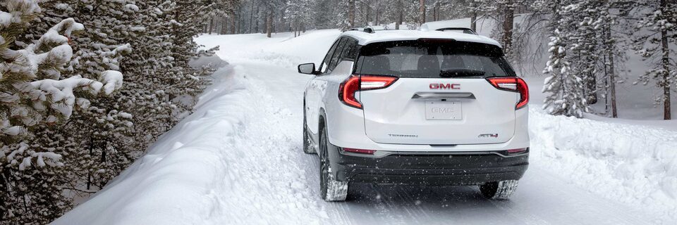 Summit White GMC Terrain AT4 Driving Off-Road On Snow In Forest
