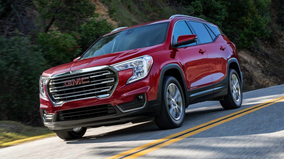 Red GMC Terrain SLT Driving On-Road With Trees and Hills