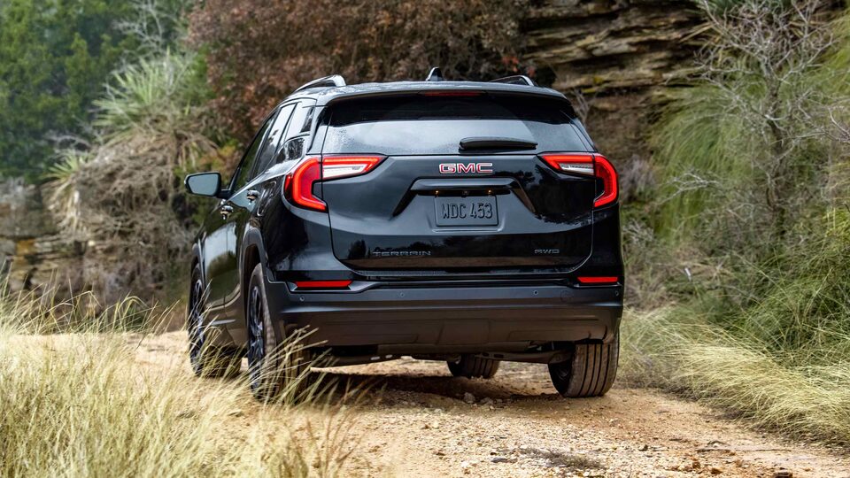 Marine Metallic GMC Terrain SLT Driving Off-Road With Dirt, Trees, and Hills
