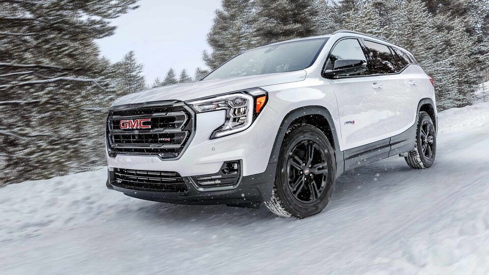 Red GMC Terrain SLT Driving On-Road With Trees and Hills