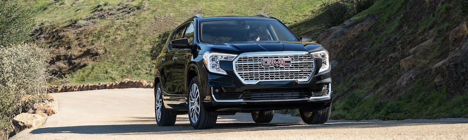The 2023 Ebony Twilight Metallic GMC Terrain Denali Driving Up a Steep Mountain Road