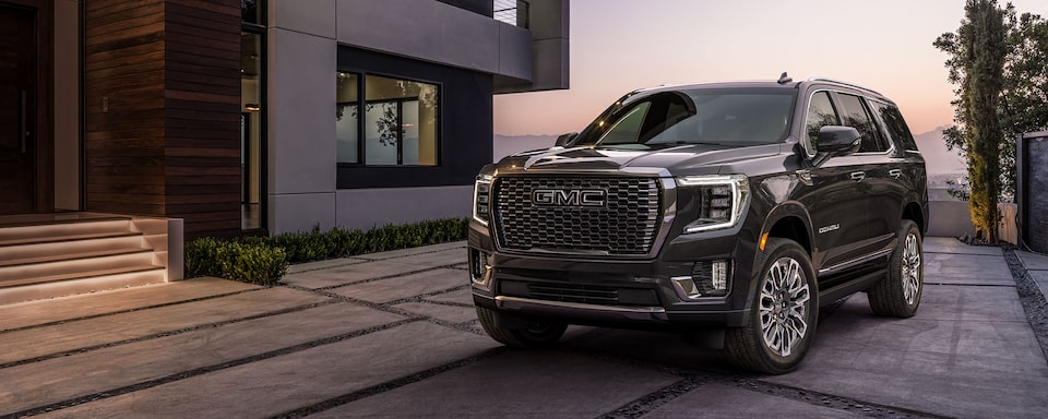 Onyx Black GMC Yukon Parked On-Road In Driveway Next to House