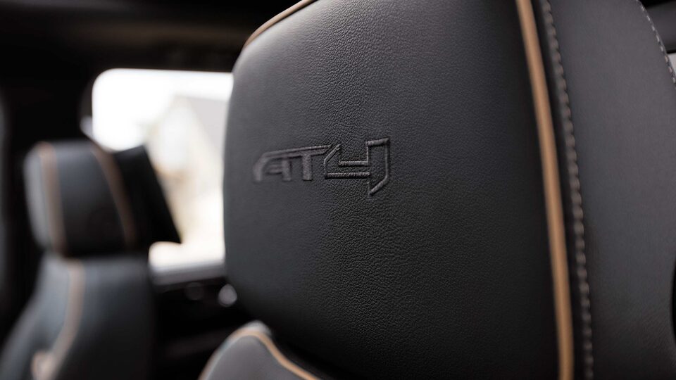 Close-Up Shot of the New Yukon AT4 Drivers Side Black Leather Seat With Stitching And "AT4" Etched Into The Headrest