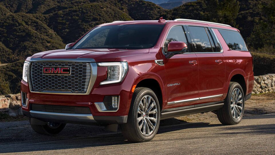 Red Yukon Denali Large Luxury SUV Parked on the Road with Hills