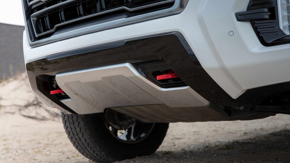 Front Tow Hooks on the White GMC Yukon AT4 Parked on Sand