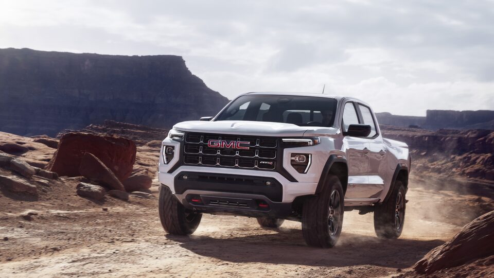 The GMC Canyon AT4 Driving on a Desert Road with a Mountain Backdrop