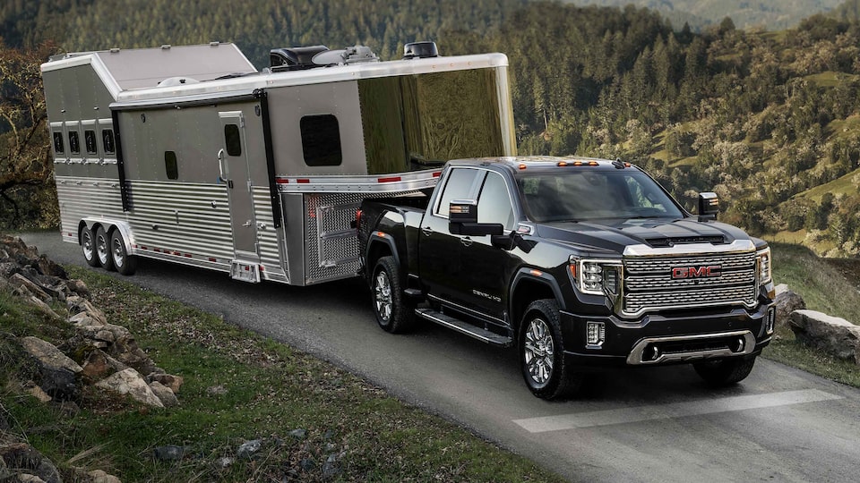 The Sierra HD On an Open Mountain Road Towing a Trailer with Ease