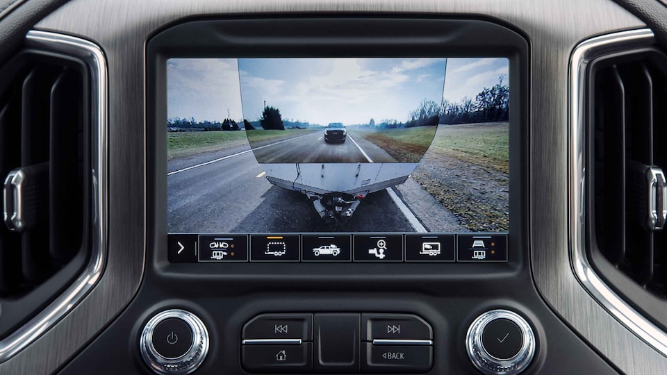 Closeup on GMC Sierra HD Infotainment System displaying Towing Camera With Trailer