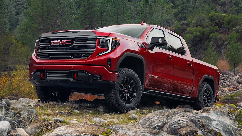 A GMC Sierra Owner Reaches in His Cooler as He Sits in His Truck Bed in the Outdoors