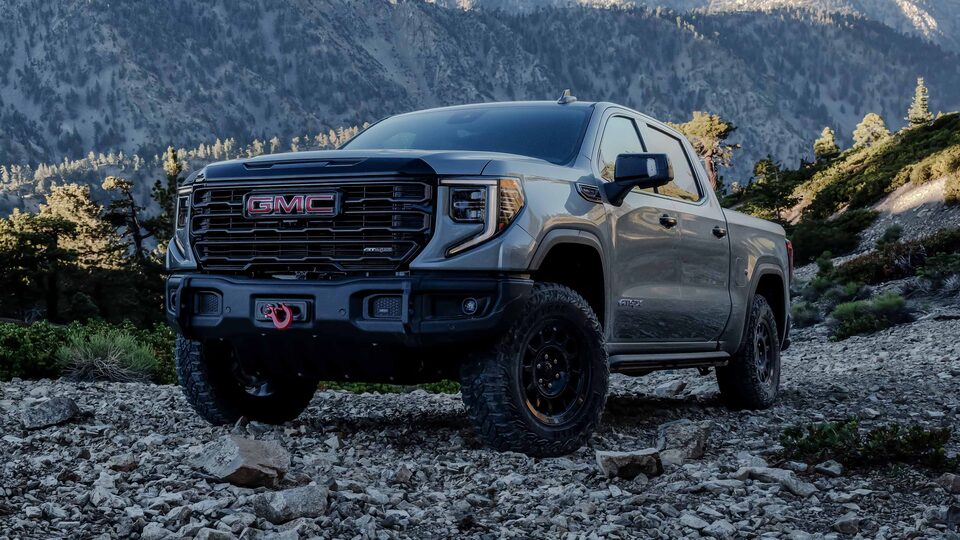 The Sierra AEV Parked in an Open Field with a Mountain Backdrop